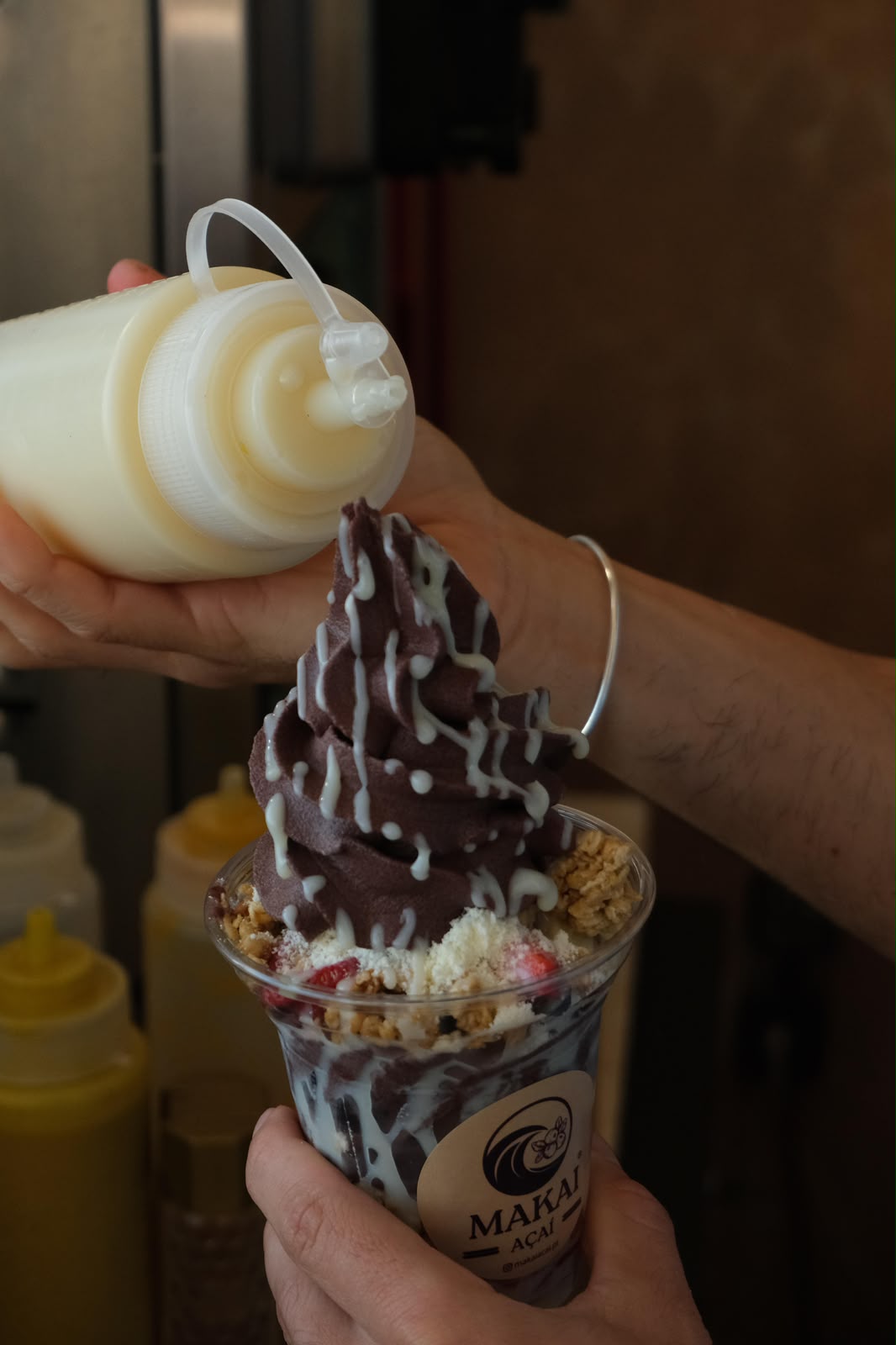 Leite condensado a ser vertido sobre açaí